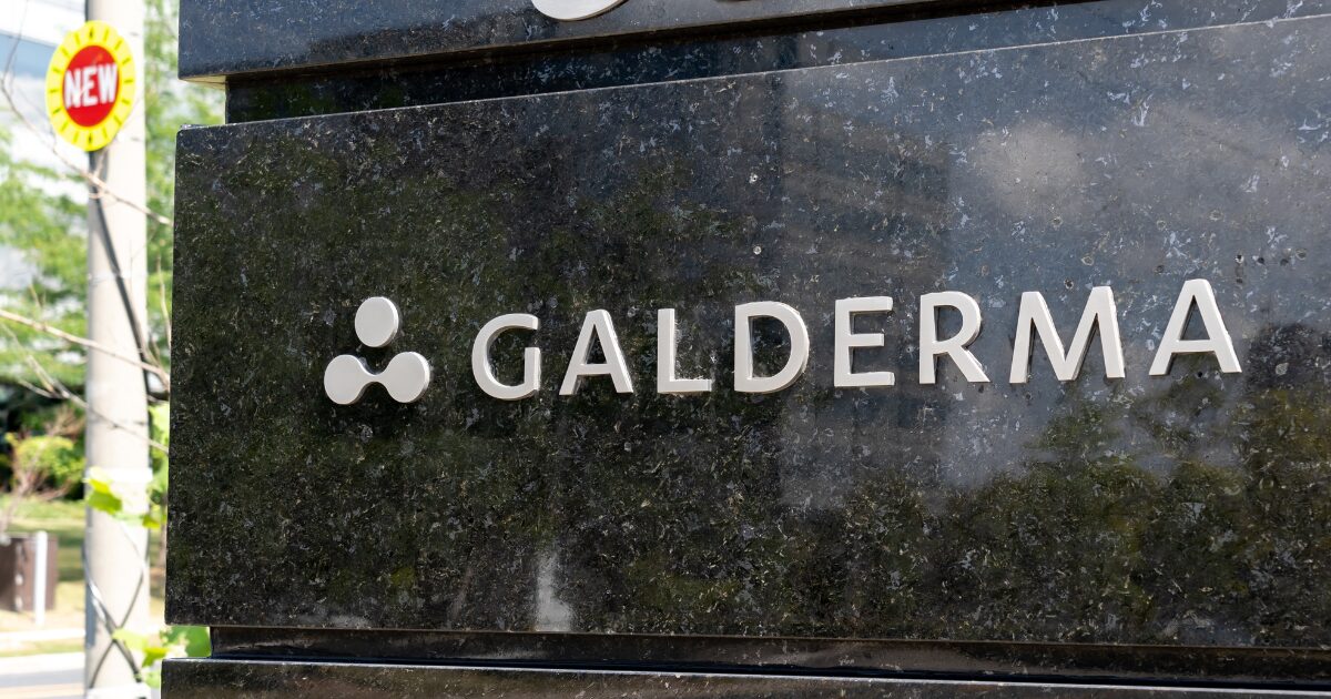 Placa de entrada da empresa Galderma, com o logotipo e nome da empresa em letras prateadas em um fundo de mármore escuro. A imagem ilustra a identidade visual da Galderma, empresa onde Eduardo Kondo foi recentemente nomeado como Global IT Head - Consumer Experience, assumindo a responsabilidade por estratégias tecnológicas voltadas à experiência do consumidor.