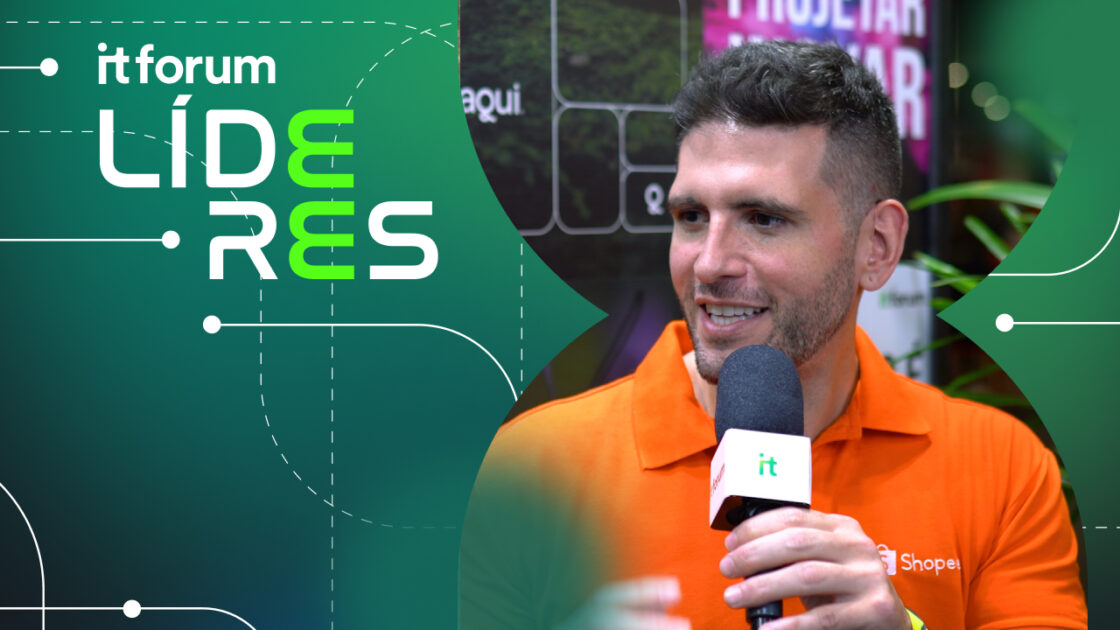 Imagem de Rodrigo Farah, head de marca de live commerce da Shopee, durante uma entrevista ao IT Forum Líderes. Ele veste uma camisa polo laranja com o logotipo da Shopee, segurando um microfone com o logo do IT Forum. O fundo destaca a identidade visual do evento, com detalhes modernos e vegetação