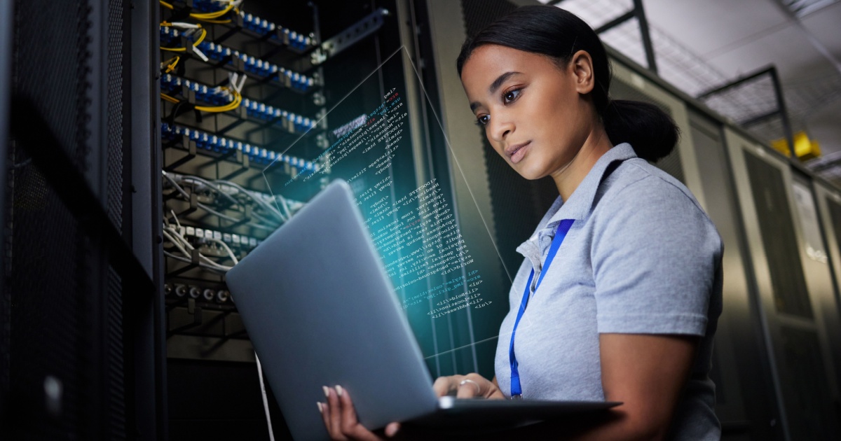 Mulher trabalhando em um data center, analisando informações em um laptop enquanto está cercada por servidores e cabos de rede. A tela do laptop exibe códigos ou dados, e ela parece concentrada, destacando um ambiente tecnológico e de alta segurança (trabalhadora, funcionária, mulher, rede, data center, networking, Cisco)