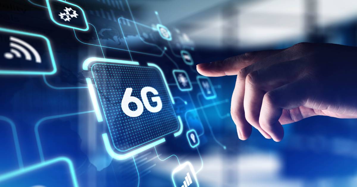 Imagem conceitual sobre tecnologia 6G. Uma mão humana aponta para uma interface digital holográfica com ícones de conectividade, incluindo um grande botão com a inscrição '6G'. O fundo apresenta um ambiente tecnológico azul iluminado, representando inovação e avanços na comunicação sem fio (brasil)