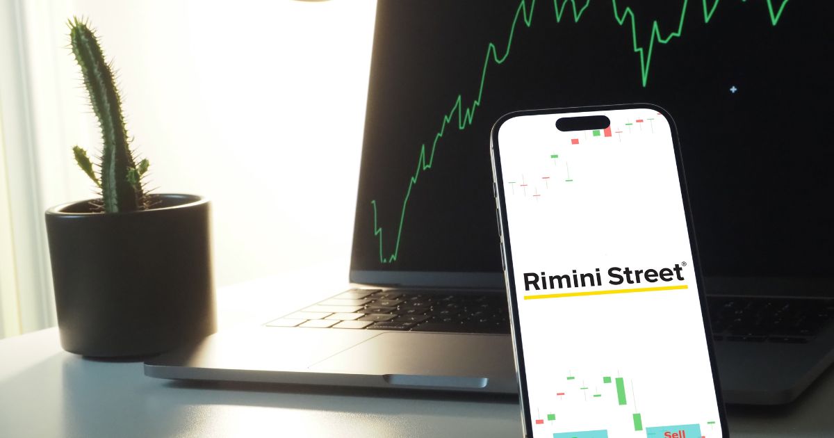 Telefone com os dizeres "Rimini Street" e um computador atrás