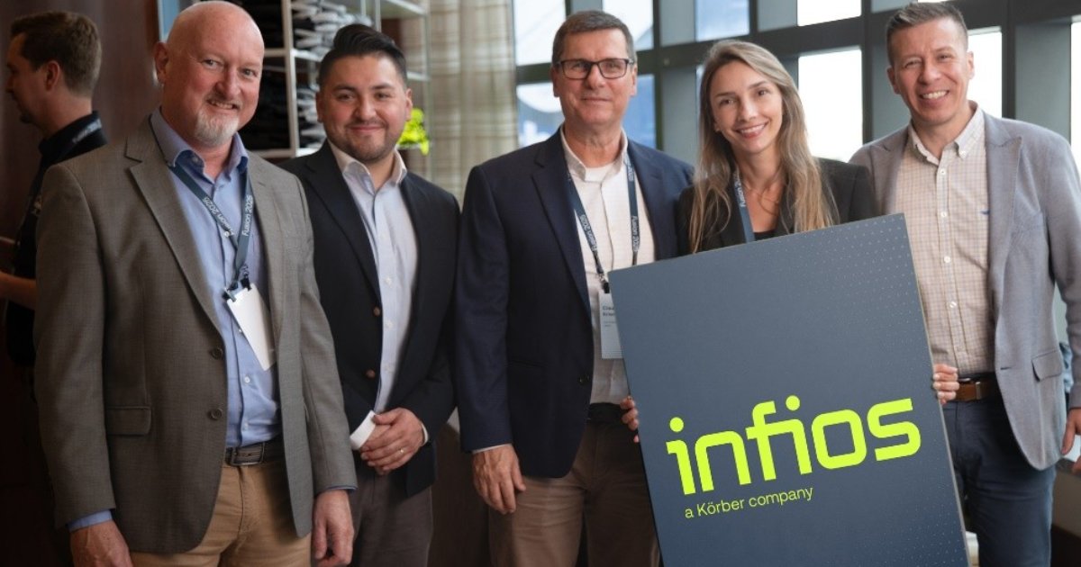 A imagem mostra um grupo de cinco pessoas vestidas com trajes formais, sorrindo e posando para a foto em um ambiente corporativo. Uma das pessoas, uma mulher, segura um grande cartaz com o logotipo "infios" e a frase "a Körber company", indicando um evento de rebranding ou parceria empresarial.