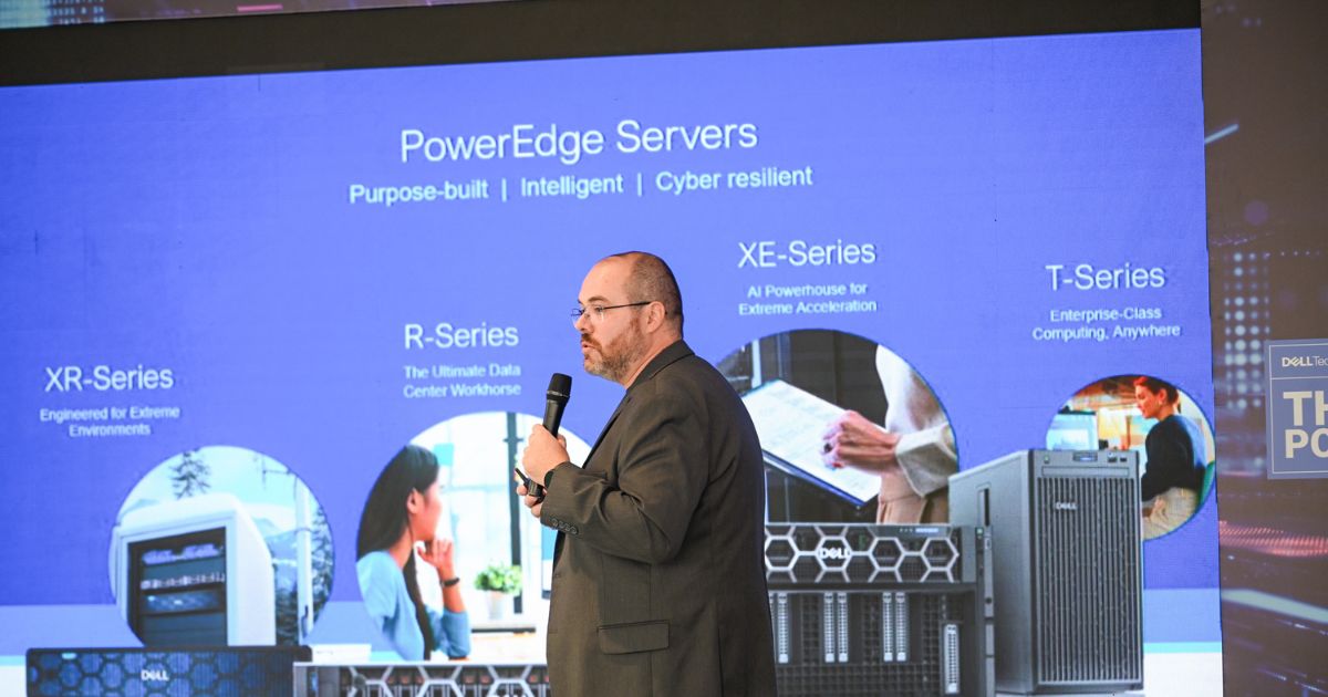 Homem careca com barba e óculos, vestido com fato escuro, segura um microfone enquanto apresenta em palco. Atrás dele, um grande ecrã exibe informações sobre servidores Dell PowerEdge, com destaque para as séries XR, R, XE e T, cada uma com descrições e imagens correspondentes. O fundo do slide é azul e a apresentação parece decorrer num evento tecnológico.