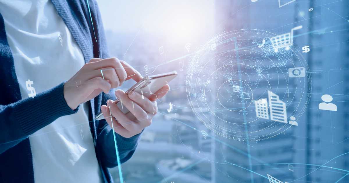 Pessoa utilizando um smartphone, com ícones digitais flutuando ao redor, representando conectividade, comércio eletrônico, nuvem, redes sociais, música e finanças. A imagem transmite o conceito de MVNO (operadora móvel virtual), destacando a integração de serviços digitais em dispositivos móveis em um ambiente urbano e tecnológico.