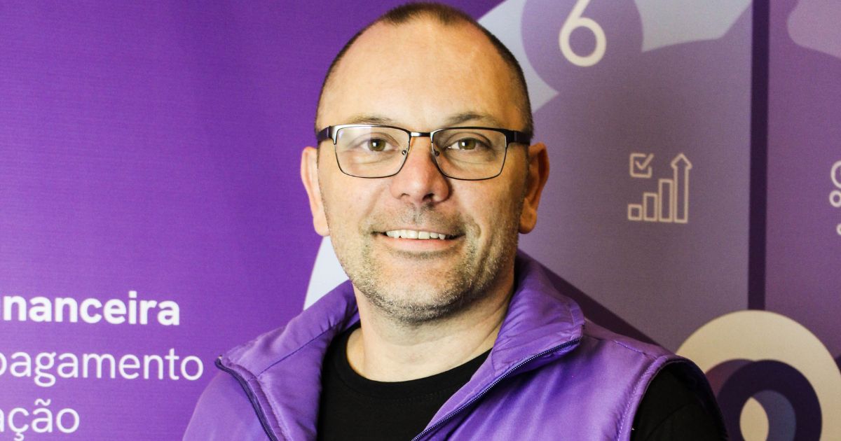 Evandor Alves, CTO da Omnik, vestindo um colete roxo com o logotipo e o texto "omnik", posicionada em frente a um fundo roxo com diversos ícones e textos em português, como "financeira", "pagamento", "importação" e "campanha". O rosto da pessoa está desfocado. O fundo também contém elementos gráficos como gráficos e números.