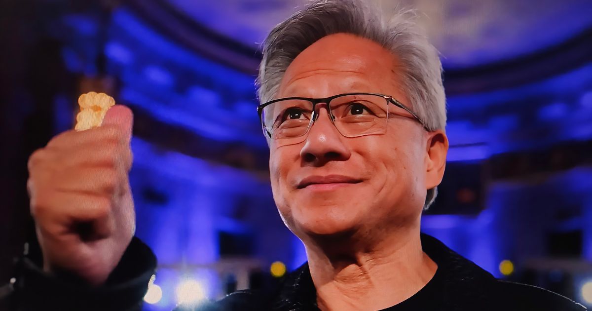 A imagem mostra uma pessoa em primeiro plano com a mão fechada em punho, destacando um anel dourado com design marcante. O fundo é composto por um ambiente interno iluminado por luzes azuis e roxas, sugerindo um espaço sofisticado ou um evento formal, possivelmente com arquitetura clássica, dado o teto curvo e detalhes ornamentais visíveis. A iluminação cria um contraste entre o brilho do anel e o cenário ao fundo, transmitindo uma sensação de destaque e poder. (IA)