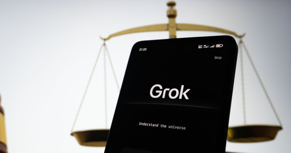 A imagem mostra um smartphone em destaque com a tela exibindo o texto “Grok” e o subtítulo “Understand the universe”. No canto superior direito, há a palavra “Skip”, indicando que pode ser uma tela inicial ou de introdução de um aplicativo ou serviço. No canto superior esquerdo, aparece o horário 21:23 e informações de rede e bateria. Contexto visual: Plano de fundo: Uma balança dourada, símbolo clássico da justiça, desfocada, sugerindo um tema relacionado a equilíbrio, ética ou decisões. Iluminação: Fundo claro com contraste entre o objeto dourado e o smartphone escuro, criando uma composição elegante e minimalista. Essa imagem transmite uma ideia de tecnologia (representada pelo app Grok) em diálogo com conceitos de justiça ou equilíbrio (representados pela balança).