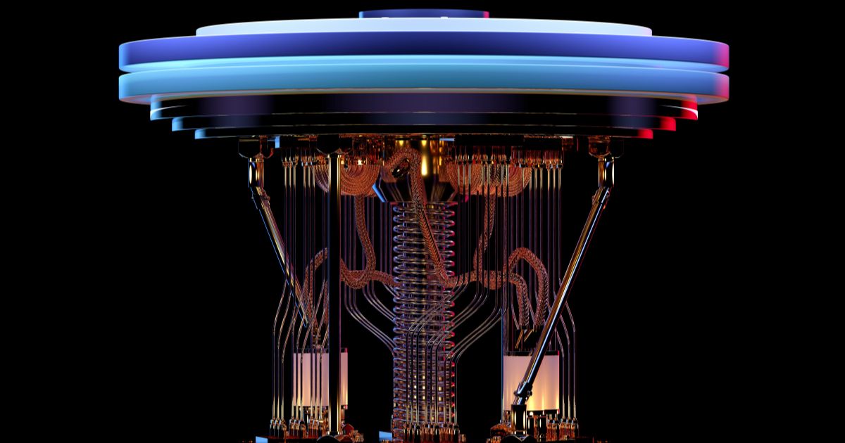 Estrutura complexa de computadores quânticos vista de frente, com diversos cabos, fios e componentes metálicos suspensos, ligados a um topo circular iluminado em tons de azul e vermelho. O fundo é totalmente preto, destacando os detalhes brilhantes e simétricos do equipamento.