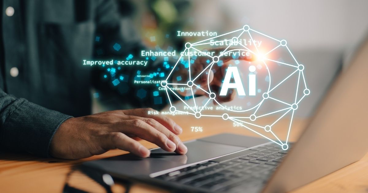 A imagem apresenta um conceito visual relacionado à Inteligência Artificial aplicada a negócios e tecnologia. Detalhes principais: Elemento central: Um laptop aberto sobre uma mesa, com mãos digitando no teclado, sugerindo trabalho ou desenvolvimento tecnológico. Sobreposição digital: Um grande ícone com a sigla “AI” dentro de uma estrutura geométrica conectada por pontos e linhas, representando redes neurais ou sistemas inteligentes. Palavras-chave flutuando ao redor, como: Innovation Scalability Enhanced customer service Improved accuracy Personalization Cost reduction Risk management Predictive analytics Percentuais como 75% e 50%, indicando métricas ou ganhos potenciais. Contexto físico: Mesa de madeira clara, ambiente interno com iluminação suave e foco no trabalho digital. Essa imagem transmite inovação, automação e impacto da IA na melhoria de processos, experiência do cliente e tomada de decisão estratégica. (liderança, IA)